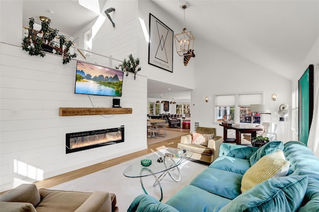 12 Bob White Dr, Water Mill, NY 11976 - living area with high vaulted ceiling, wood finished floors, a glass covered fireplace, and an inviting chandelier