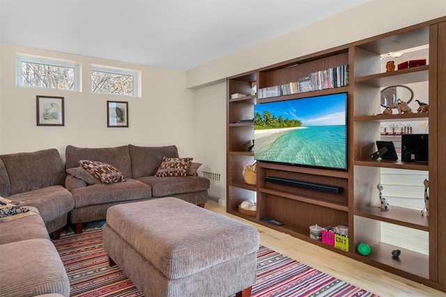 living area with radiator and wood finished floors