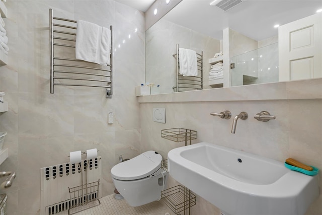 full bath with tile walls, radiator heating unit, and visible vents