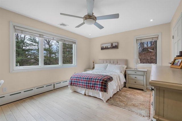 bedroom featuring visible vents, recessed lighting, ceiling fan, a baseboard heating unit, and light wood-type flooring