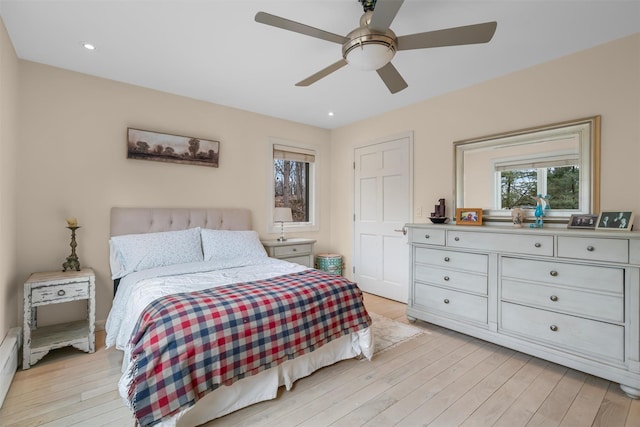 bedroom featuring light wood finished floors, baseboard heating, recessed lighting, and ceiling fan