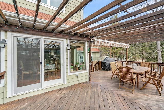 wooden terrace with outdoor dining area and grilling area