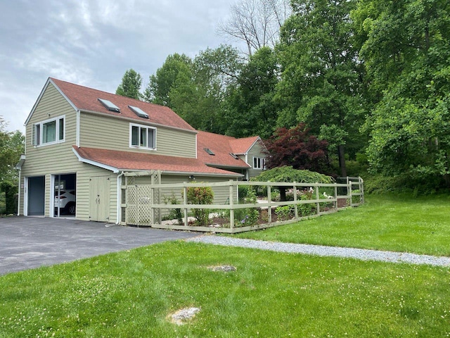 view of front of property with a garage, driveway, a shingled roof, and a front yard