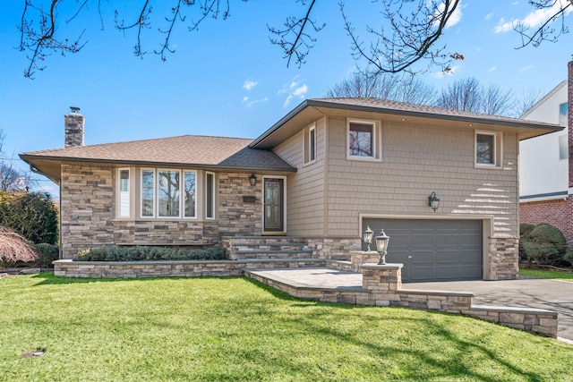 split level home with a front lawn, a chimney, a garage, stone siding, and driveway