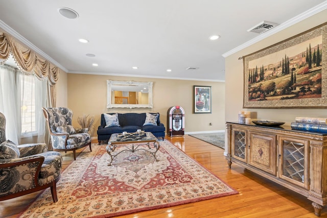 living room featuring baseboards, visible vents, recessed lighting, ornamental molding, and light wood-type flooring