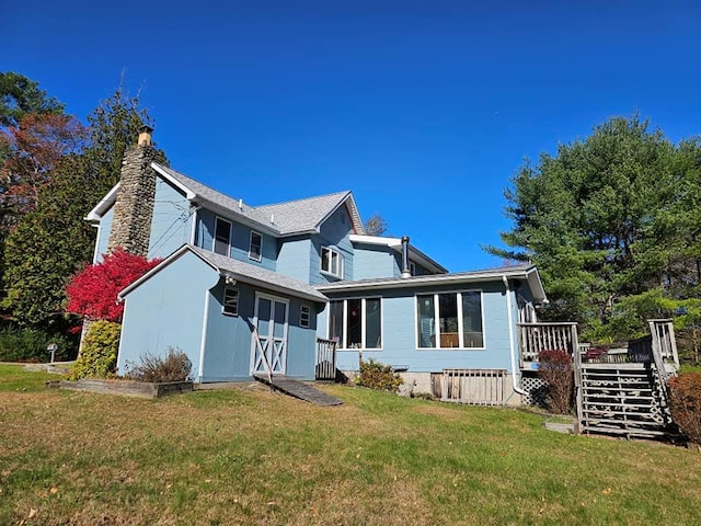 view of front of house with an outdoor structure, stairway, a wooden deck, a chimney, and a front yard