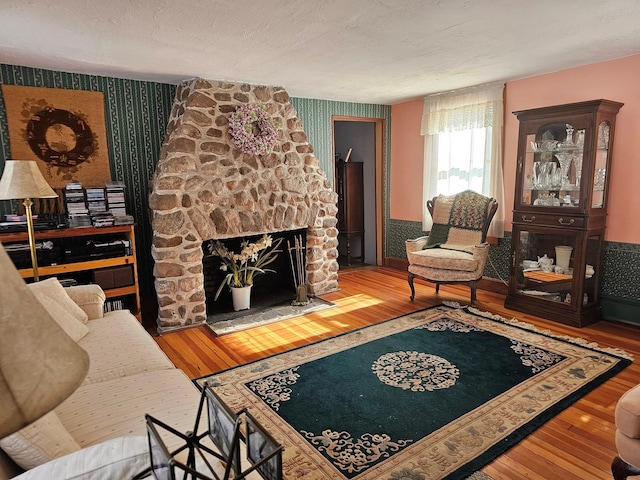 living area featuring hardwood / wood-style floors, a fireplace, and wallpapered walls