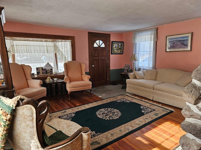 living area with a textured ceiling and wood finished floors