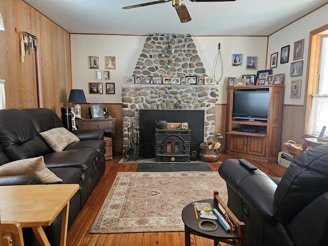 living room with a baseboard radiator, a wainscoted wall, and wallpapered walls