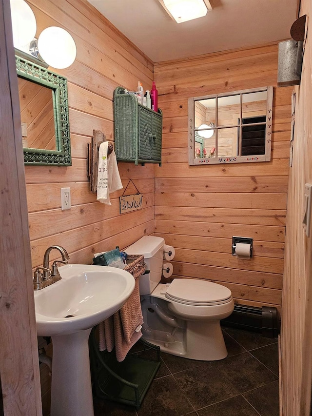 half bathroom featuring wooden walls, toilet, and tile patterned floors