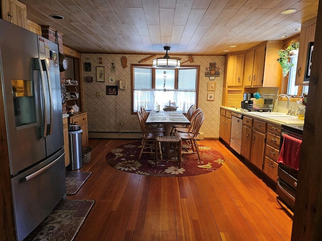 kitchen featuring electric range oven, stainless steel fridge with ice dispenser, a sink, and wallpapered walls