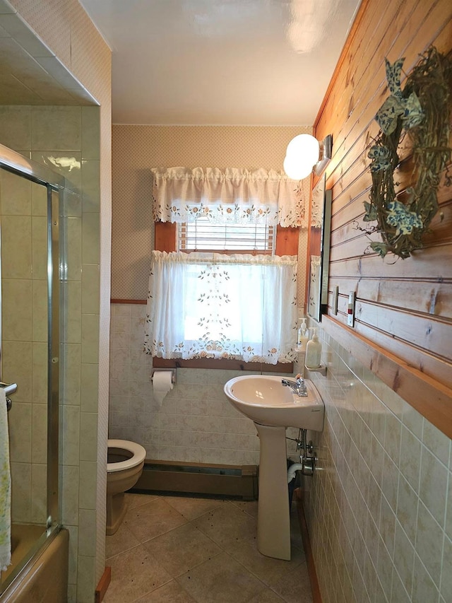 bathroom featuring a baseboard heating unit, a sink, tile patterned flooring, and toilet