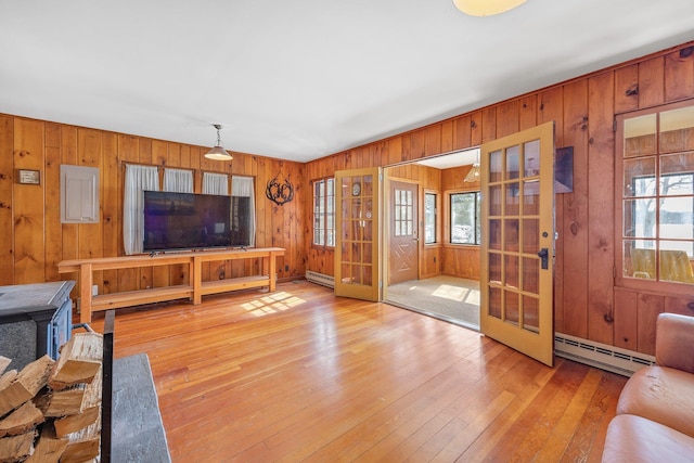 living area featuring light wood finished floors, plenty of natural light, and baseboard heating