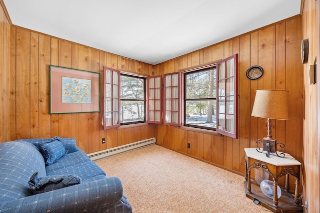 sitting room featuring a baseboard radiator, wood walls, and carpet