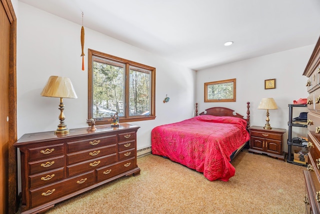 bedroom with a baseboard heating unit and light colored carpet