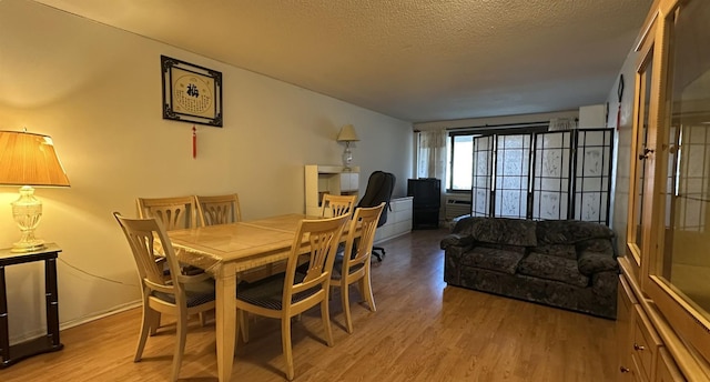 dining room with a textured ceiling and light wood-style floors