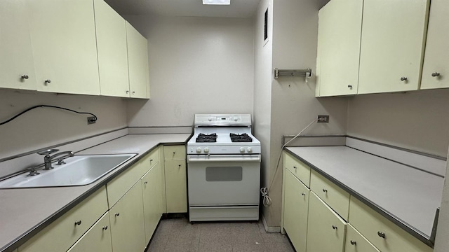 kitchen featuring a sink, light countertops, and gas range gas stove