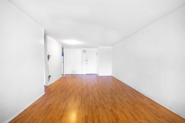 empty room with light wood finished floors and baseboards