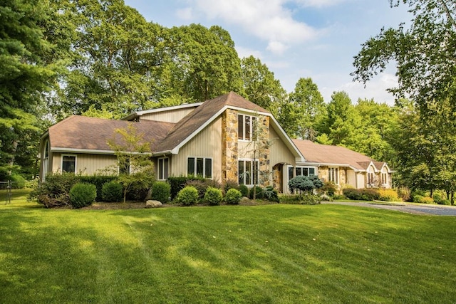 view of front facade with a front yard and stone siding