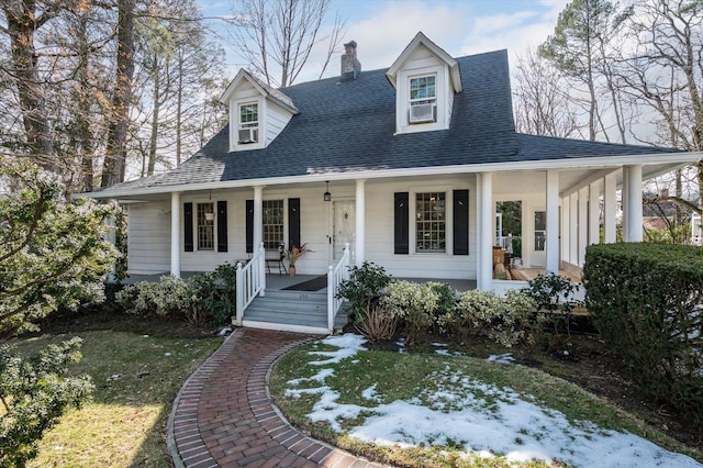 view of front of property featuring a porch, a shingled roof, and a chimney