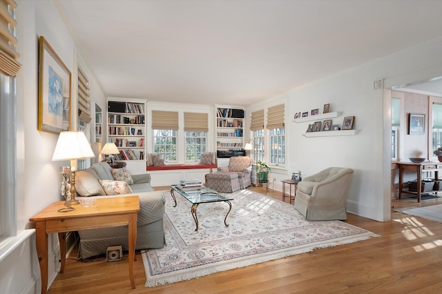 living area with ornamental molding and wood finished floors