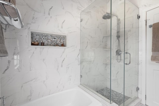 full bathroom with a garden tub and a marble finish shower