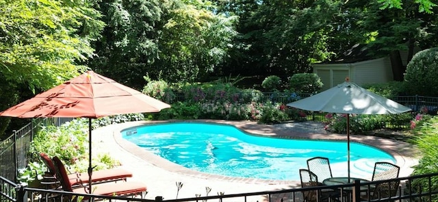 view of swimming pool featuring a fenced in pool, outdoor dining space, a patio area, and fence