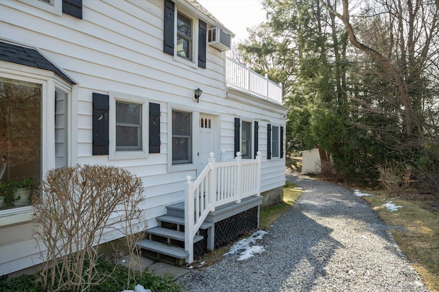 view of front of property with gravel driveway and a balcony