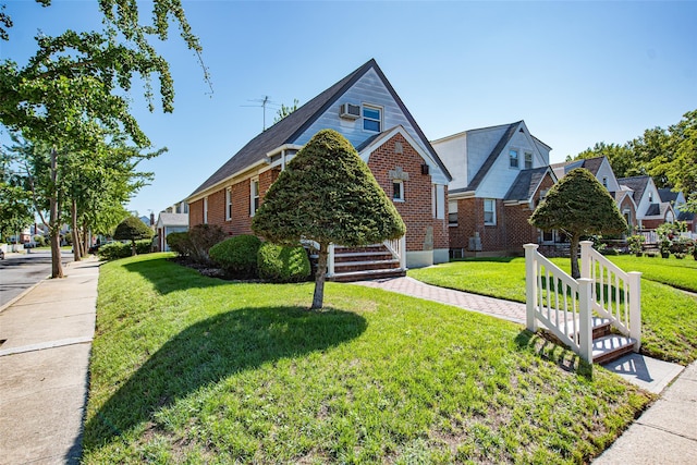 view of front of home with brick siding, a front lawn, and a residential view