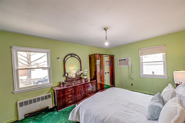 bedroom featuring multiple windows, radiator heating unit, and a wall mounted AC