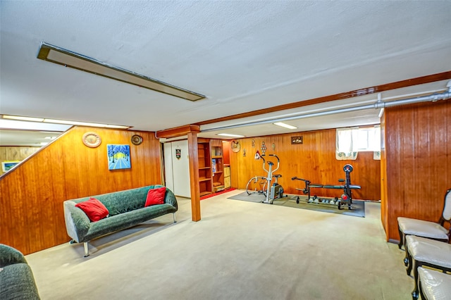 workout room featuring carpet, wooden walls, and a textured ceiling