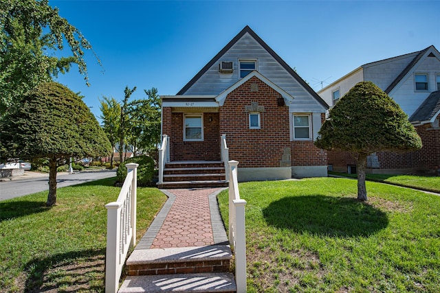 bungalow featuring a front yard and brick siding