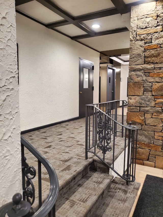 hallway featuring coffered ceiling, an upstairs landing, and baseboards