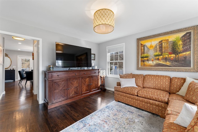 living room with dark wood-type flooring, a wealth of natural light, and baseboards