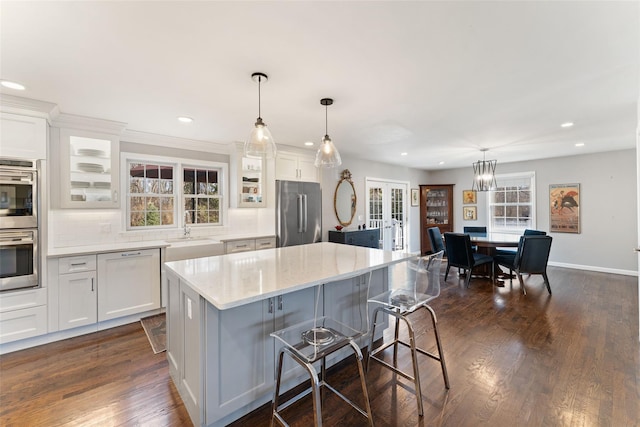 kitchen featuring stainless steel appliances, white cabinets, and dark wood finished floors