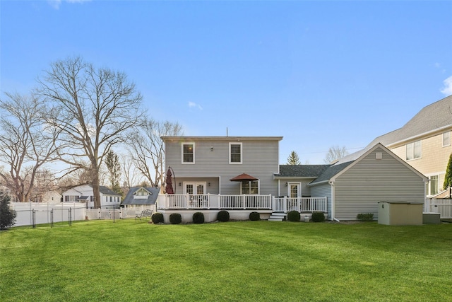 rear view of property with fence, a deck, and a lawn