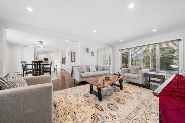 living room featuring baseboards, wood finished floors, and recessed lighting