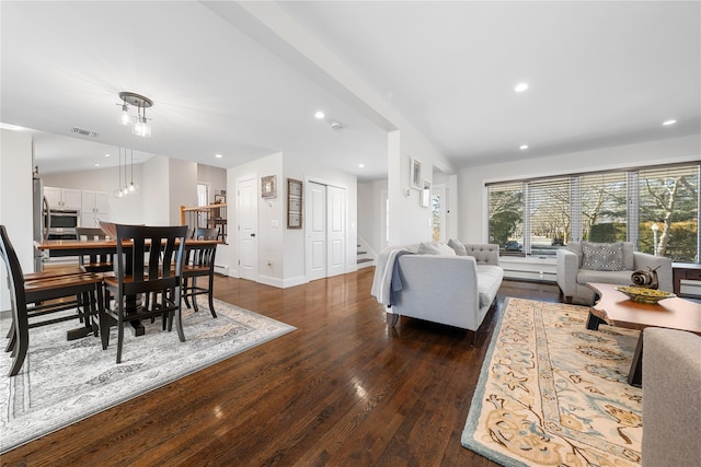 living area with recessed lighting, wood finished floors, visible vents, baseboards, and vaulted ceiling