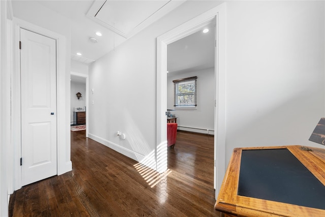 corridor featuring a baseboard heating unit, wood finished floors, attic access, and baseboards