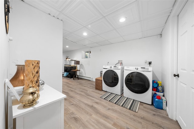 laundry room featuring light wood-type flooring, laundry area, baseboard heating, and independent washer and dryer