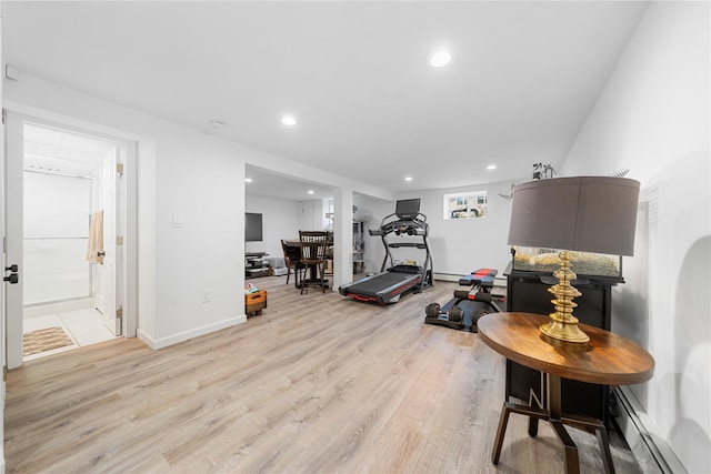 workout room with a baseboard heating unit, baseboards, light wood-style flooring, and recessed lighting