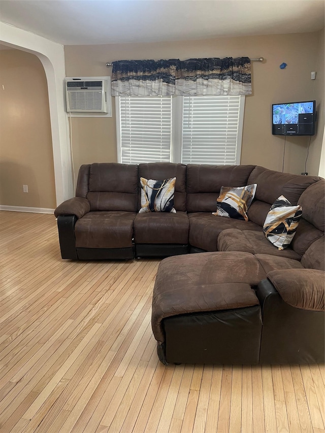 113-21 203rd St, Saint Albans, NY 11412 - living area with wood-type flooring, arched walkways, a wall unit AC, and baseboards