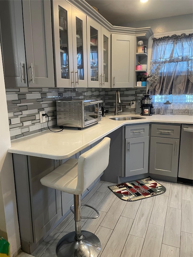 113-21 203rd St, Saint Albans, NY 11412 - kitchen featuring a sink, gray cabinetry, tasteful backsplash, and light countertops