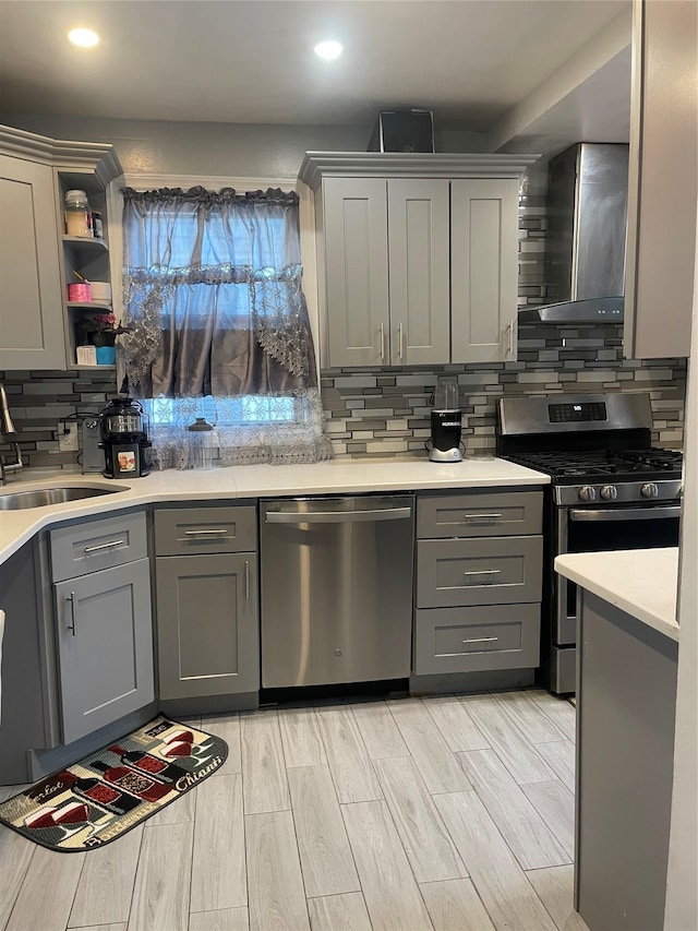 113-21 203rd St, Saint Albans, NY 11412 - kitchen with appliances with stainless steel finishes, gray cabinets, wall chimney exhaust hood, backsplash, and recessed lighting