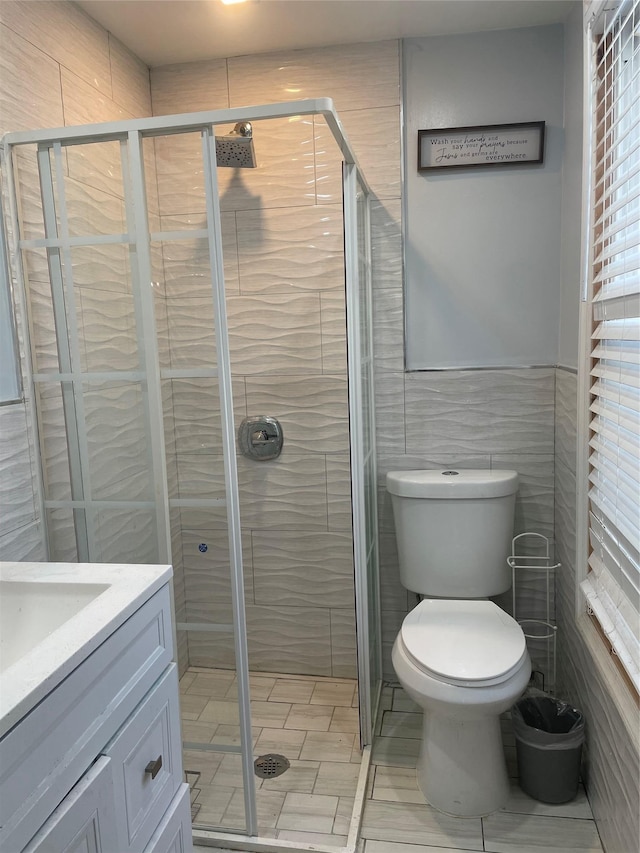 113-21 203rd St, Saint Albans, NY 11412 - bathroom with a stall shower, toilet, tile walls, and vanity