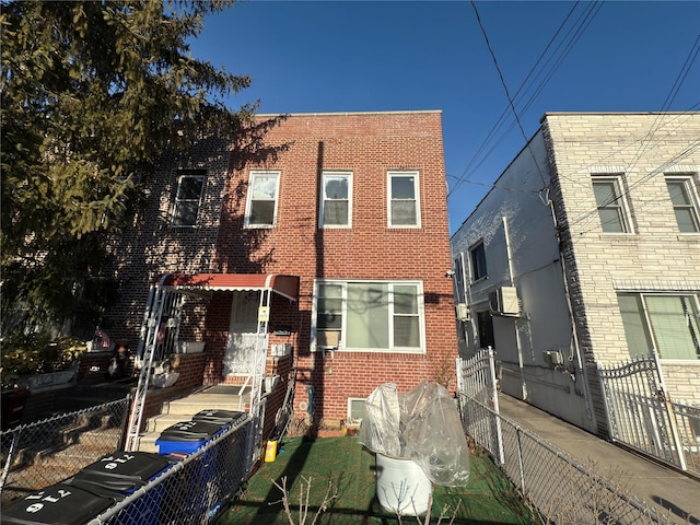 rear view of house with brick siding and fence