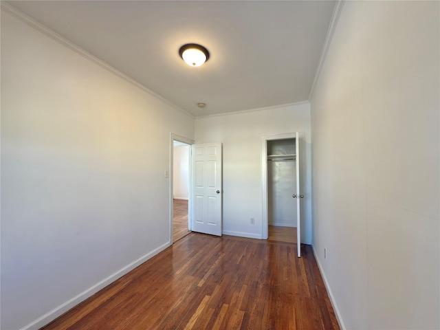 unfurnished bedroom with baseboards, ornamental molding, and dark wood-style flooring