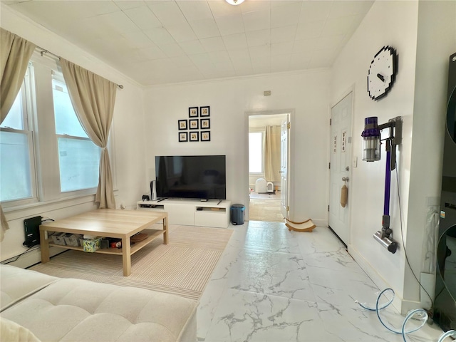 living area featuring crown molding, marble finish floor, and baseboards