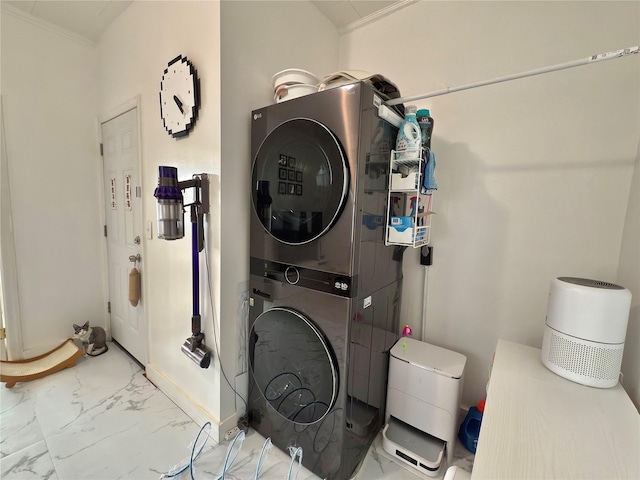 washroom featuring stacked washer and dryer, laundry area, crown molding, and marble finish floor