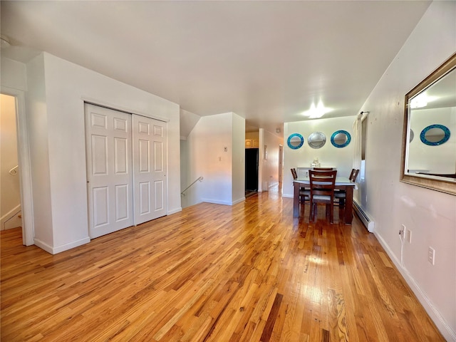 interior space with light wood-type flooring, baseboards, and baseboard heating